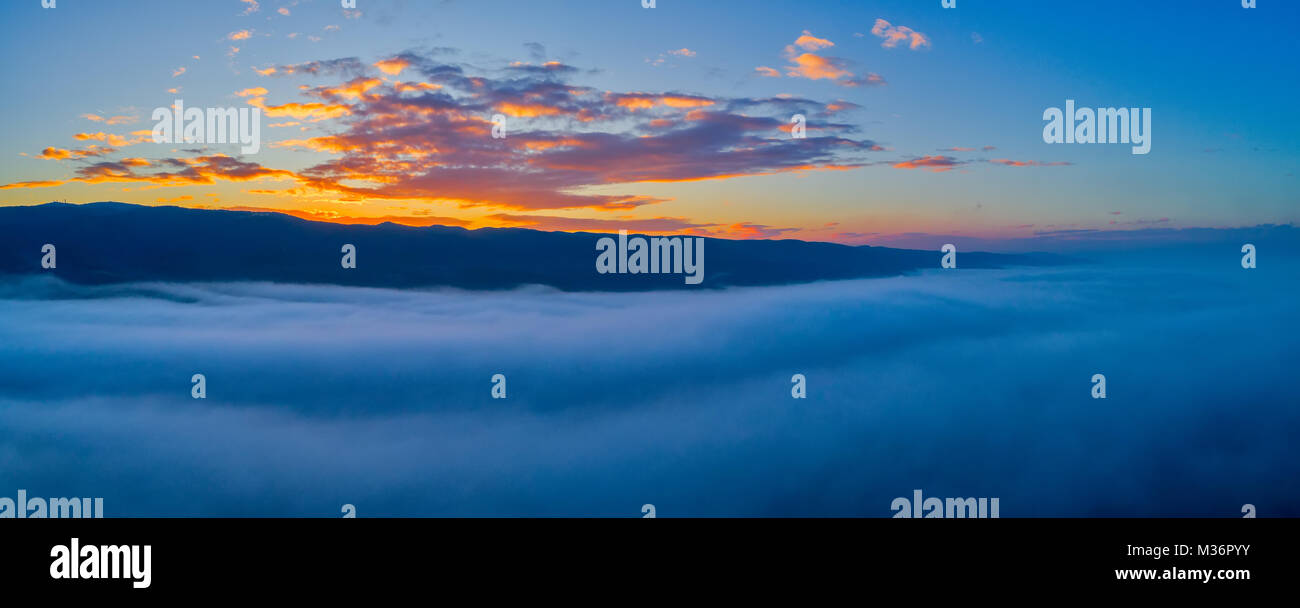 Luftaufnahme. Fliegen über den Wolken. Antenne Kamera geschossen. Während des Sonnenuntergangs. Landschaft Panorama. Stockfoto