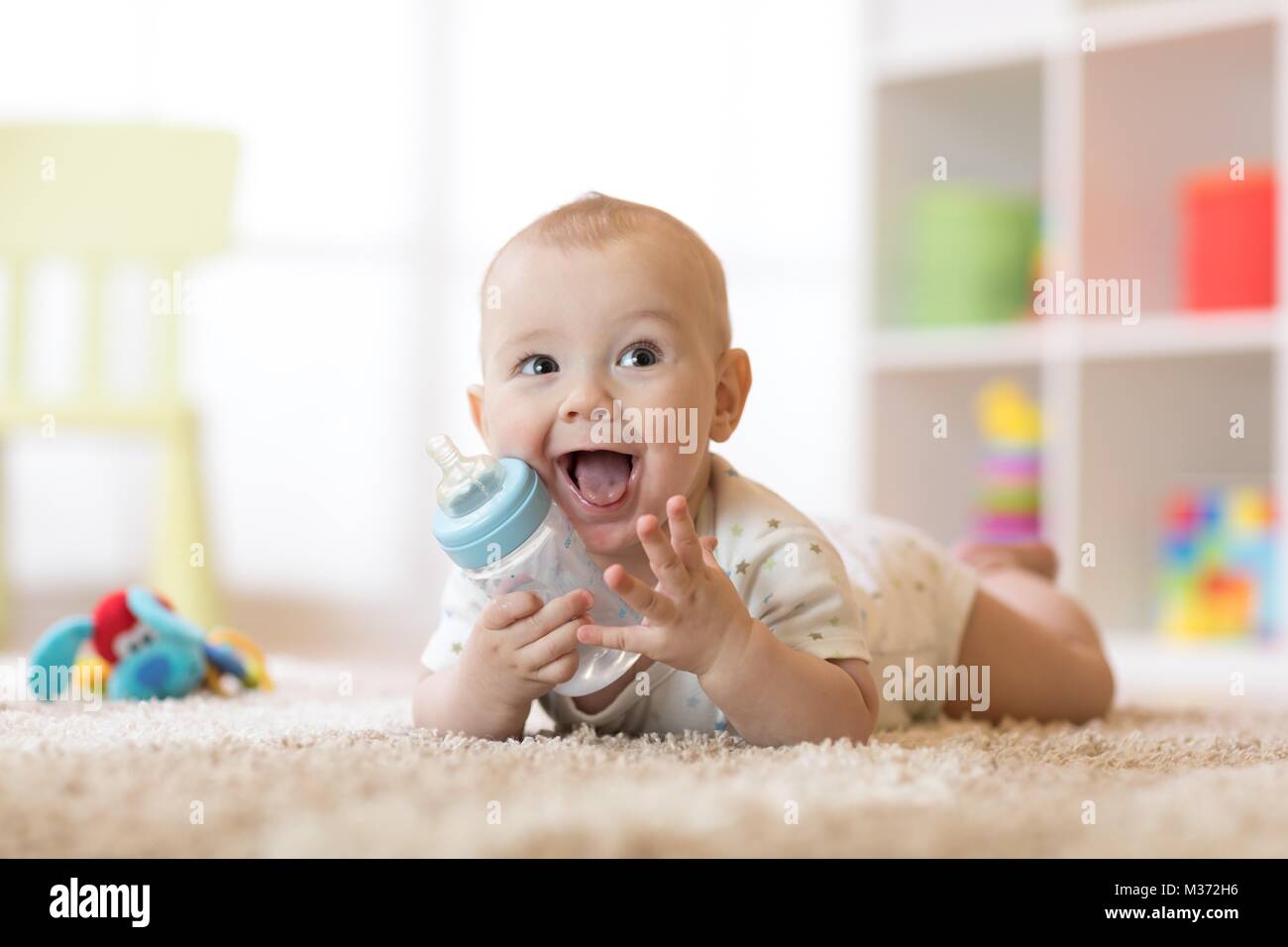 Cute Baby Boy das Trinken aus der Flasche. Lächelnd Kind ist 7 Monate alt. Stockfoto