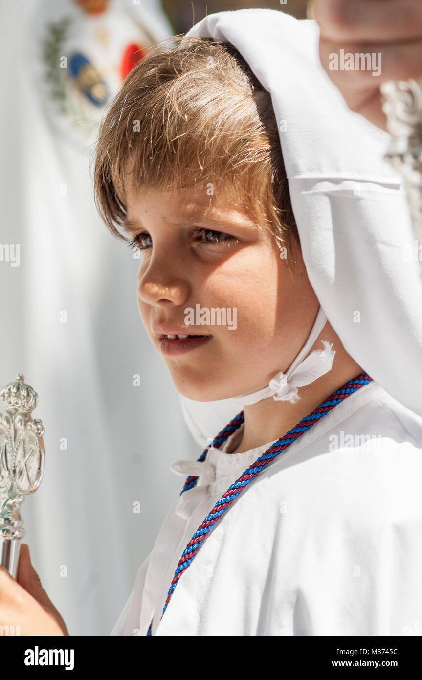 Büßer Kind der Bruderschaft des "La Paz", mit dem erhabenen Maske und einem Stock des Befehls in der Hand. Stockfoto