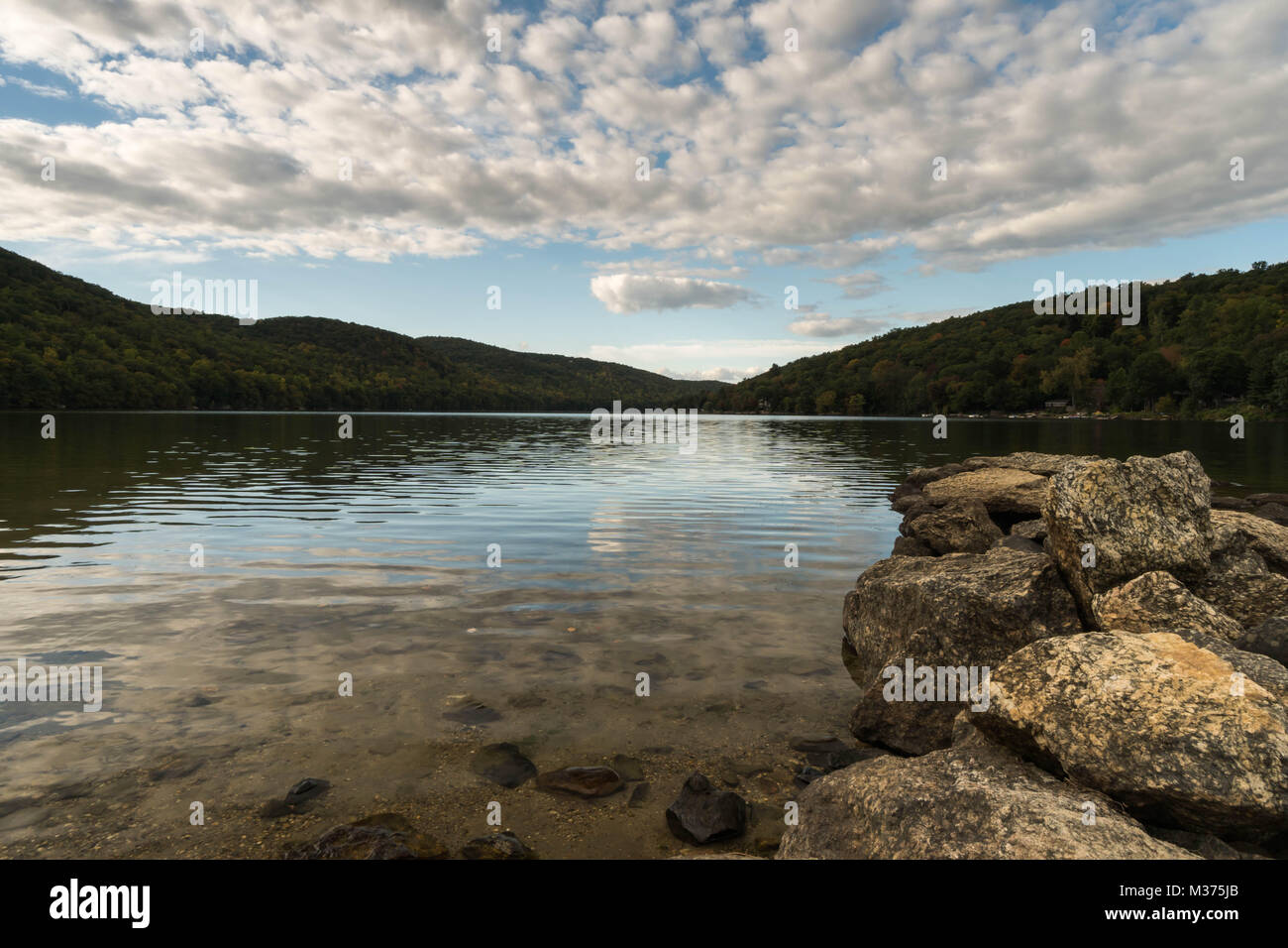 Wunderschöne Mew England Mountain Lake mit Reflexionen und Felsen im Vordergrund Stockfoto