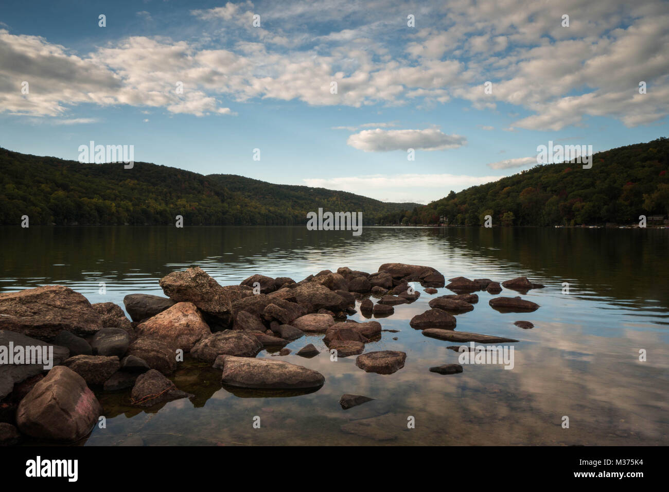 Wunderschöne Mew England Mountain Lake mit Reflexionen und Felsen im Vordergrund Stockfoto