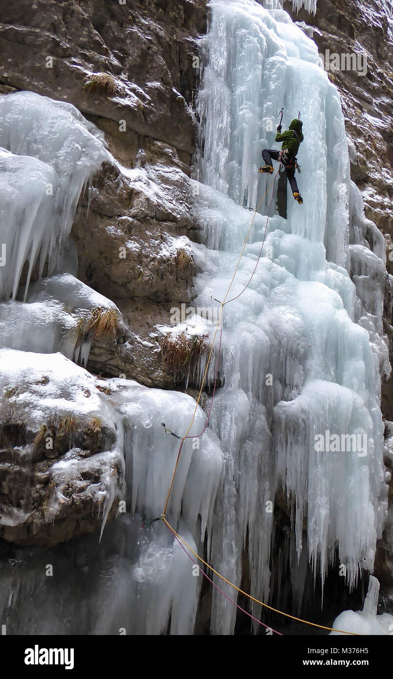 Männliche Eiskletterer auf einem steilen und gefrorenen Wasserfall im Serres di Sottoguda in den italienischen Dolomiten Stockfoto