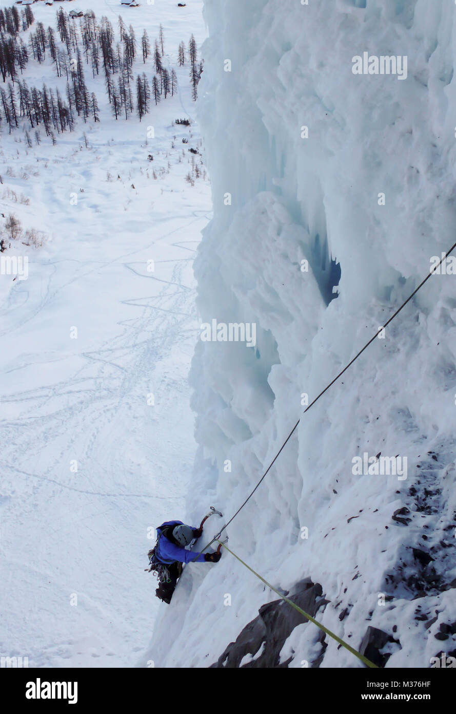 Eiskletterer auf einem steilen und gefrorenen Wasserfall im tiefen Winter Stockfoto