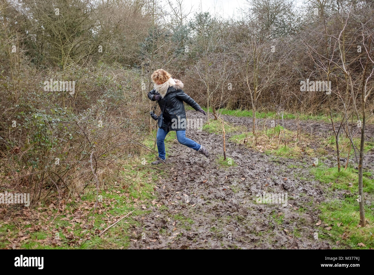 Pulborough Brooks RSPB Nature Reserve in West Sussex UK-Frau Kämpfe durch einen schlammigen Weg zu gehen Stockfoto