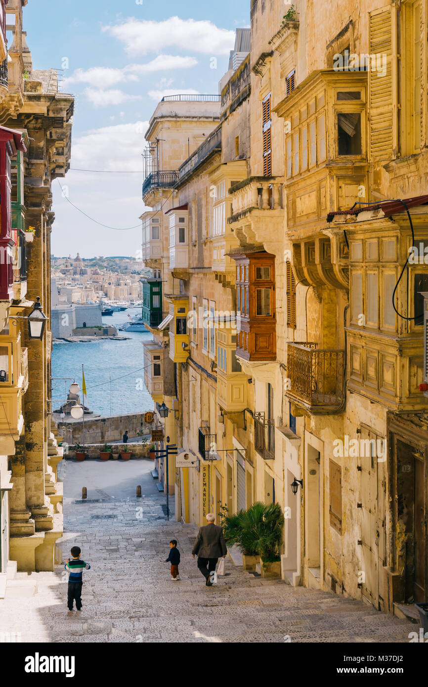 Valletta, Malta - 12. März 2017: Altstadtstraße mit traditionellen maltesischen Balkonen und faszinierendem Meerblick. Morgenstunden Stockfoto