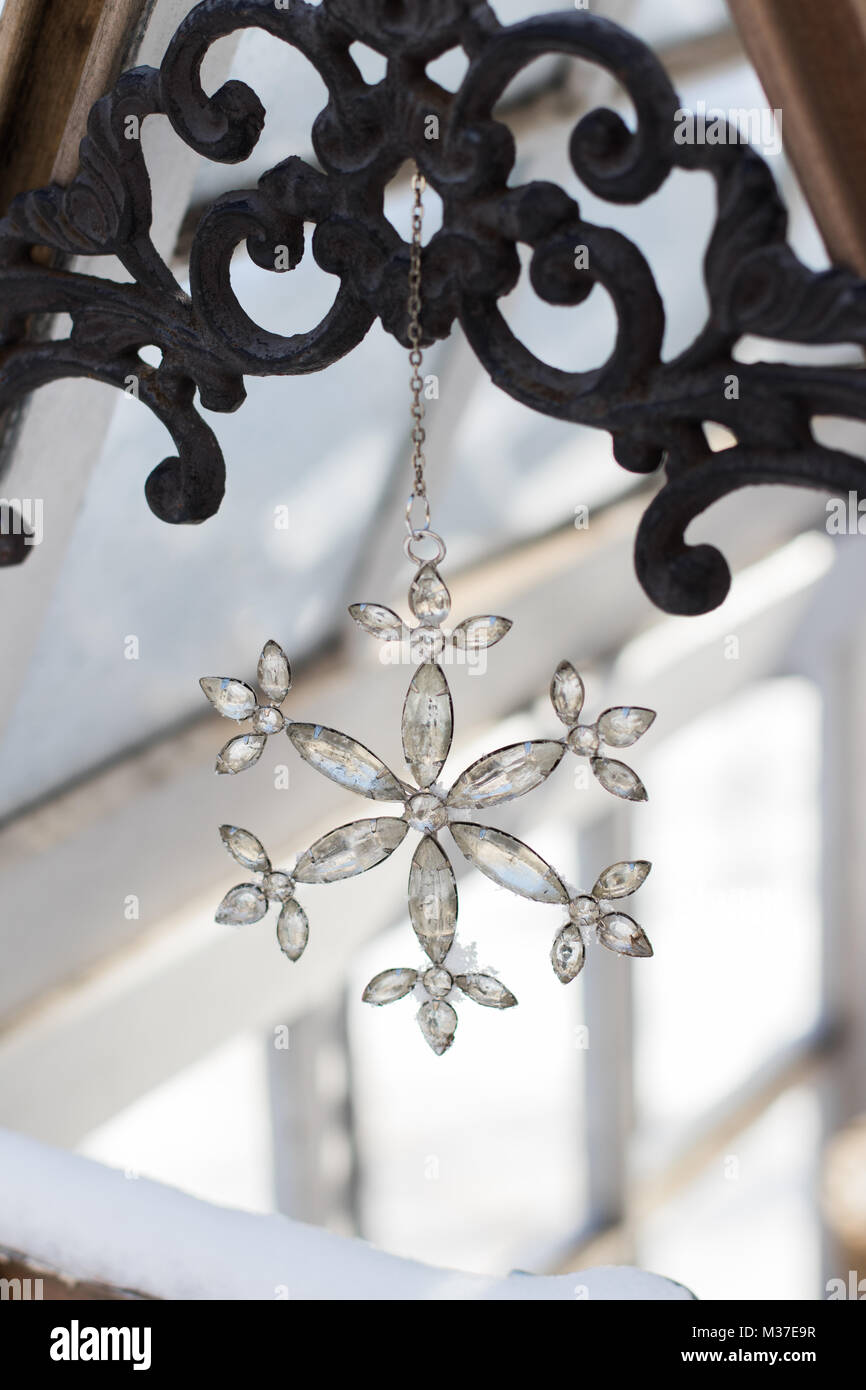 Schneeflocke ornament hängend im Gewächshaus auf sonnigen Wintertag. Stockfoto