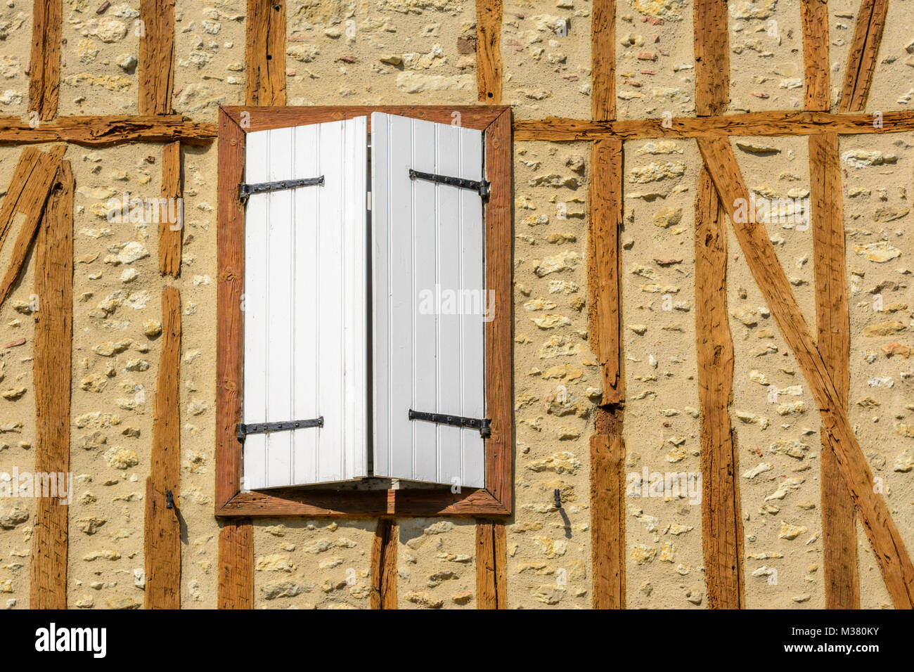 Fenster mit weißen Fensterläden aus Holz auf einem Fachwerkhaus in Barran, Gers (Gascogne), Occitanie (Midi-Pyrénées), im Südwesten von Frankreich Stockfoto