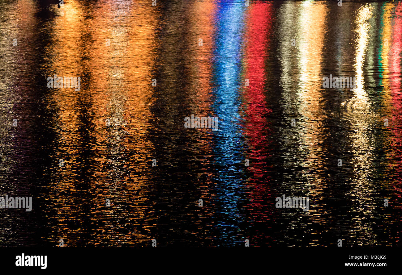 Bunte Lichter im Wasser des Hafens in Camborne Cornwall in der Nacht wider. Stockfoto