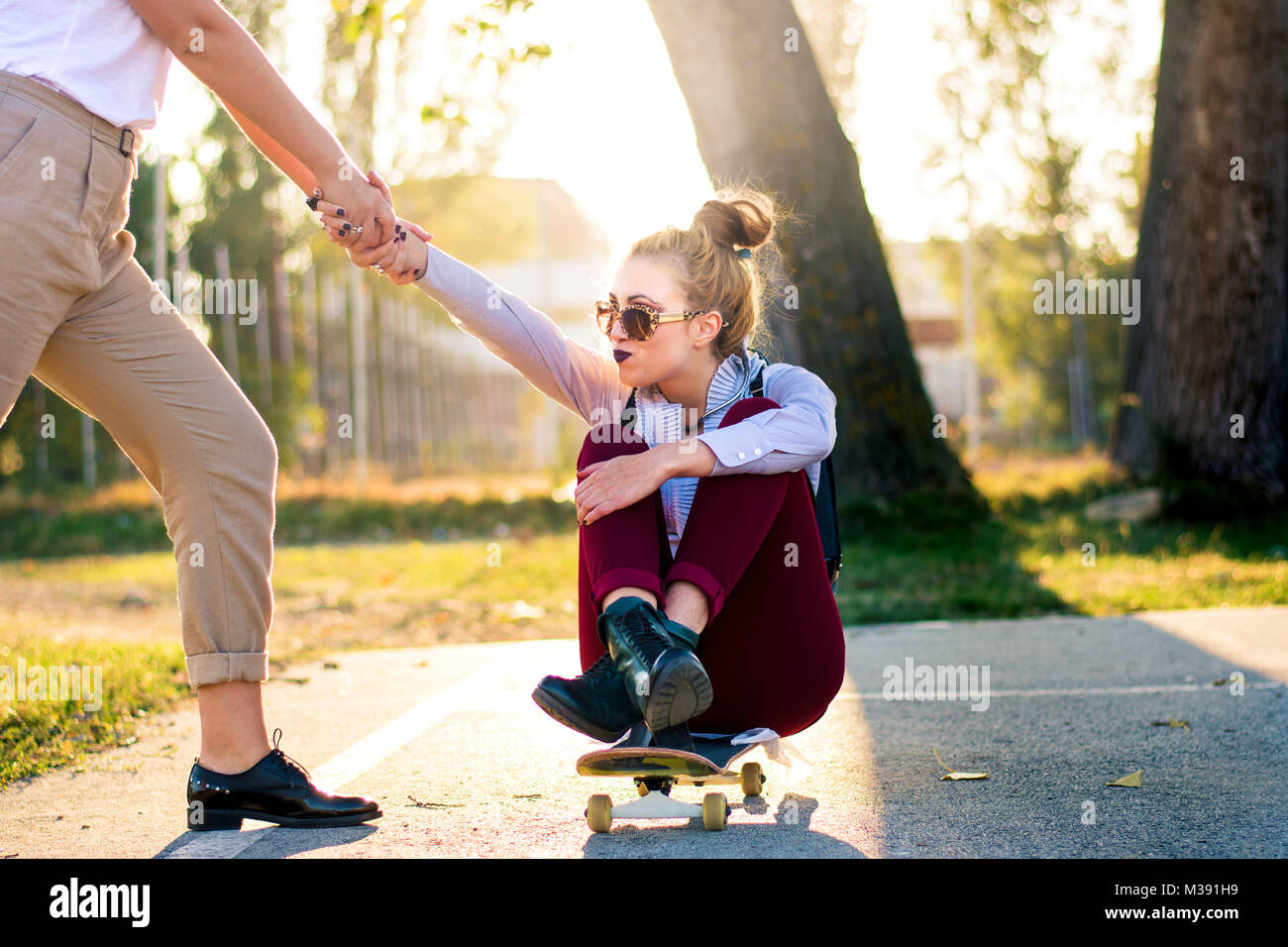 Zwei Mädchen Spaß mit einem Skateboard im Park Stockfoto