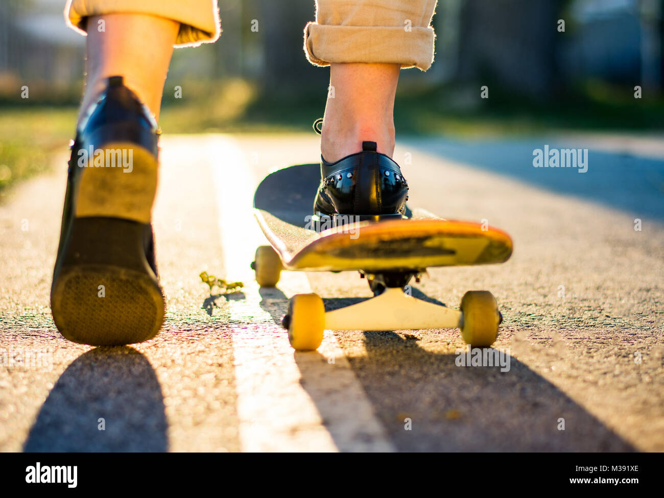 Weibliche reiten ein Skateboard bei Sonnenuntergang. Stadt urban Lifestyle Stockfoto