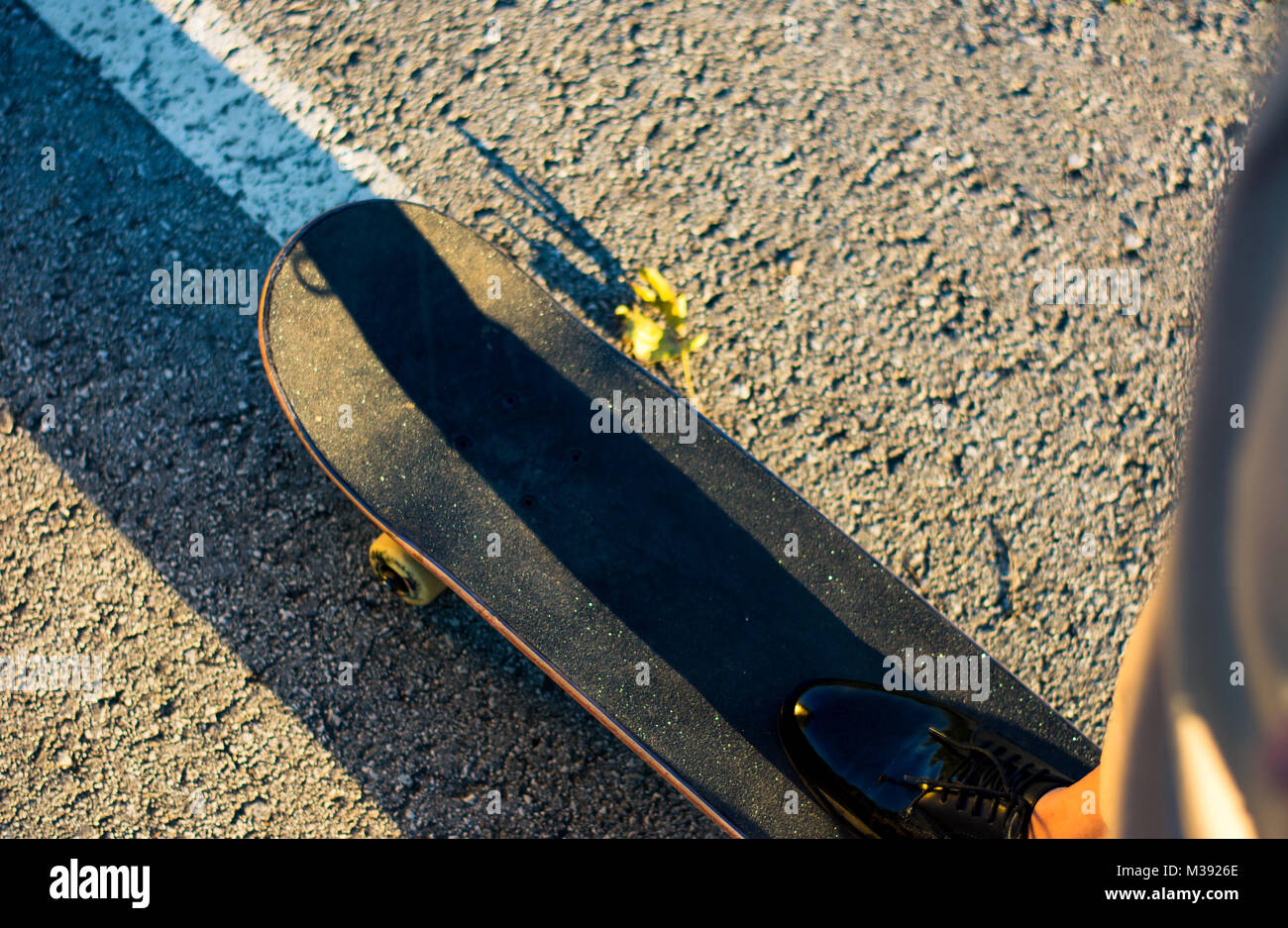 Weibliche reiten ein Skateboard bei Sonnenuntergang first person Ansicht Stockfoto