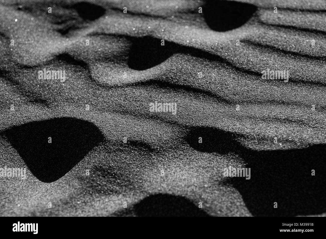 Schwarze Wellen von Sand Stockfoto