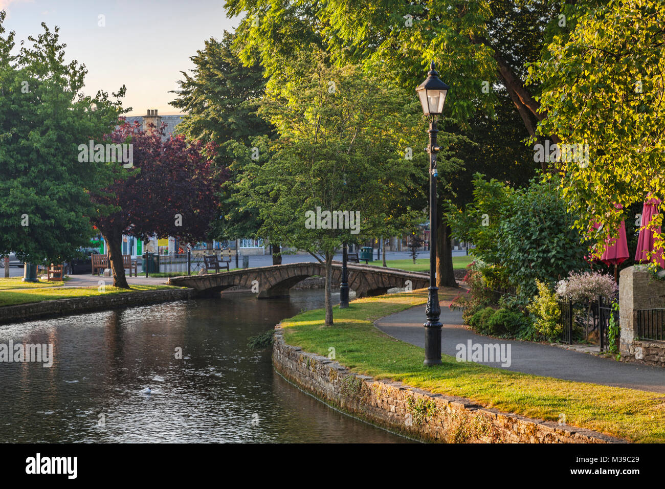 Der Fluss Windrush fließt unter der berühmten Brücke aus Stein in den Cotswolds Dorf Bourton-on-the-Water, Gloucestershire, England Stockfoto