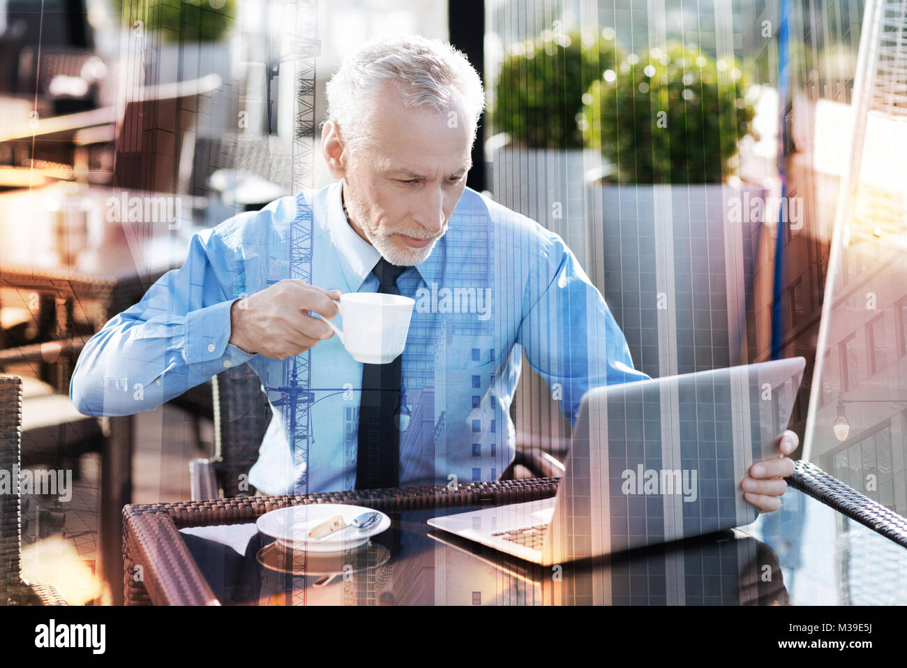Konzentriert reifer Mann Kaffee trinken und auf den Bildschirm Stockfoto