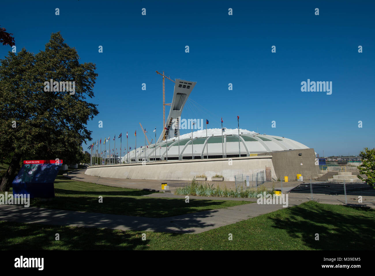 Olympic Park Dome historische Lifestyle Spiel Medaille Gold Silber Parks Flaggen Schatten Bäume Wandwände Sommer blauer Himmel sonniges Wetter Läufer Stockfoto