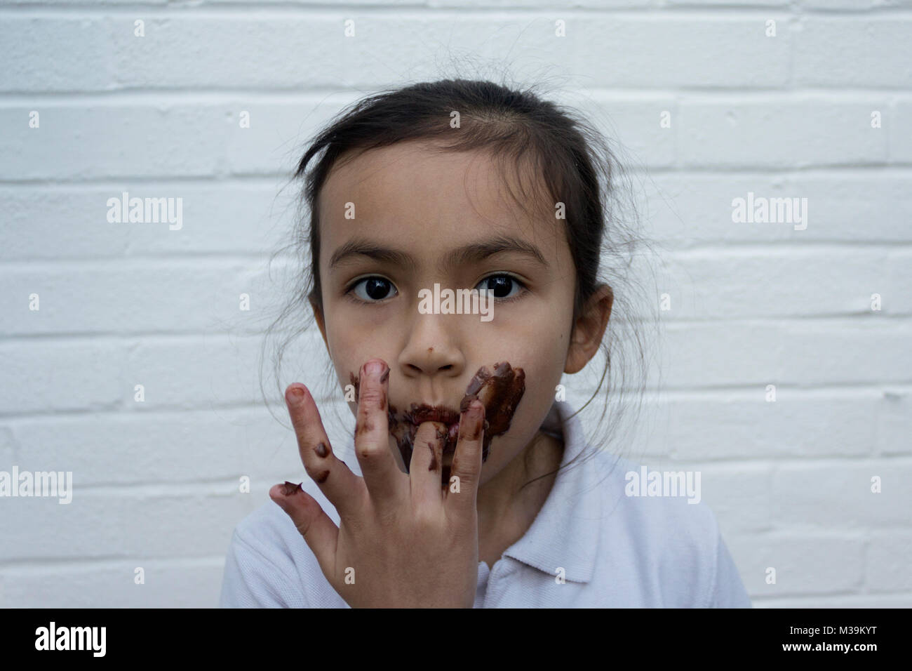 Kind Schokolade essen mit Chaos auf dem Gesicht Stockfoto