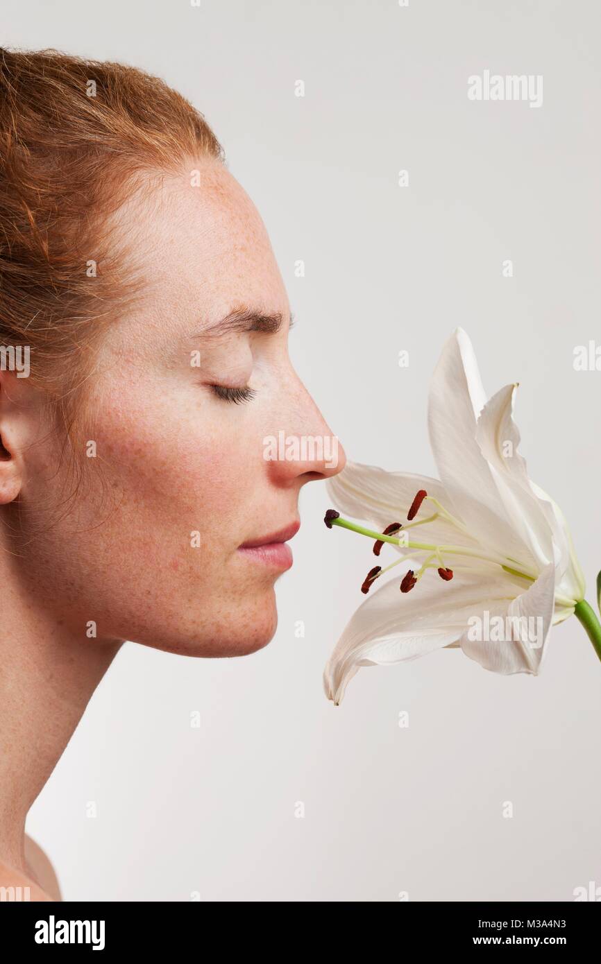 MODEL RELEASED. Profil von weiblichen Gesichts duftende weiße Lilie Blume. Stockfoto