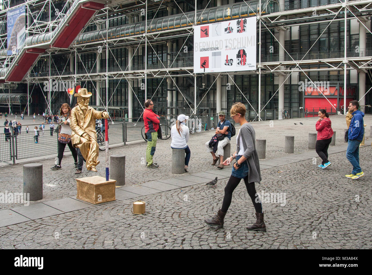 Mädchen spendet für ein Street Performer als lebende Statue auf Platz Georges Pompidou mit dem Centre Pompidou im Hintergrund. Paris, Frankreich. Stockfoto