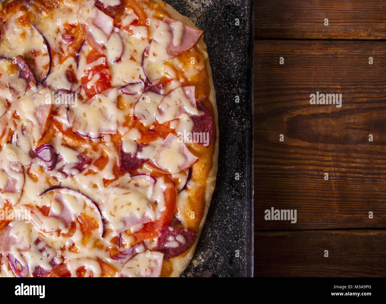 Hausgemachte Pizza auf einem rustikalen Holztisch Stockfoto