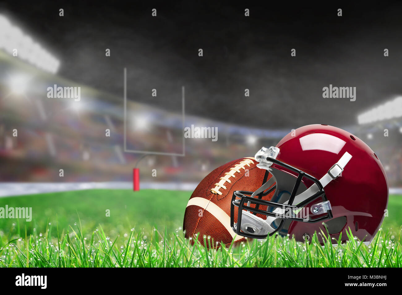 American football Helm und Ball auf Feld Gras in Hell im Stadion mit Fokus auf Vorder- und flache Tiefenschärfe auf Hintergrund beleuchtet. De Stockfoto