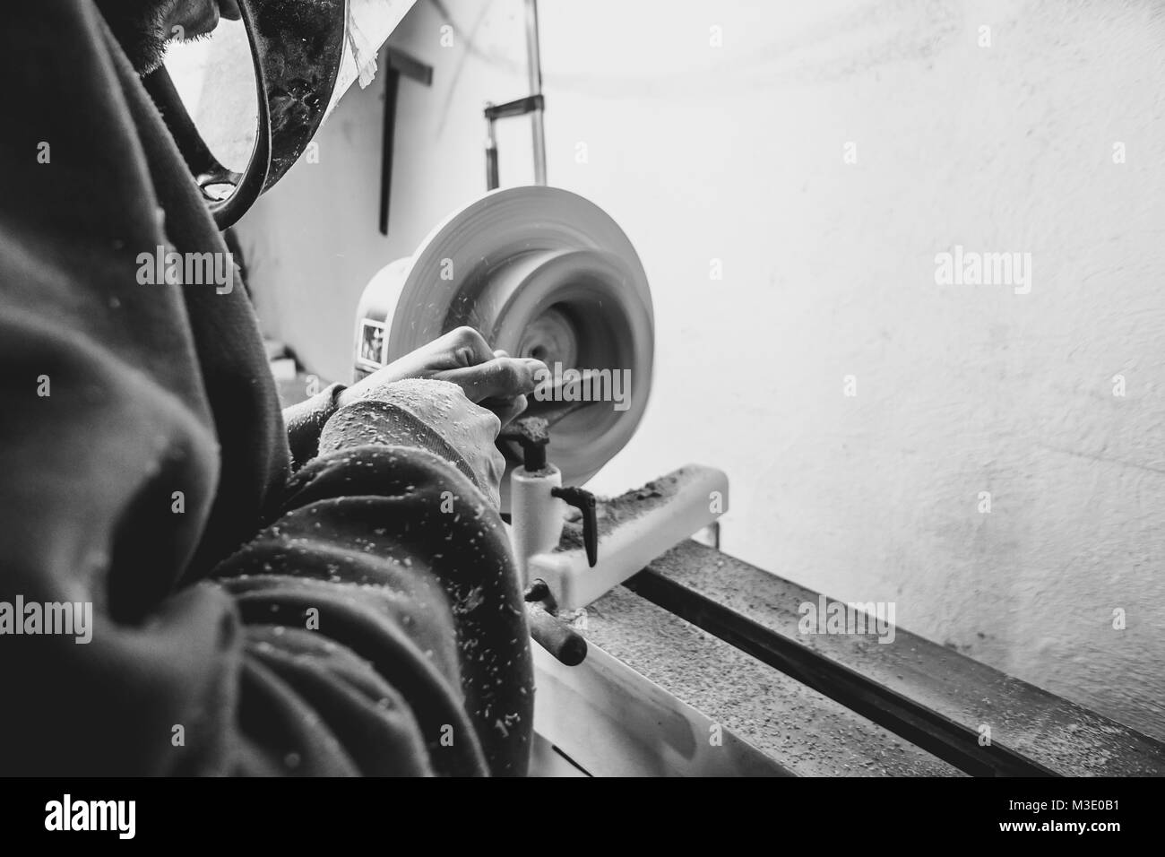 Der Arbeitnehmer wird das Holz auf einer Drehmaschine in seiner Werkstatt Stockfoto