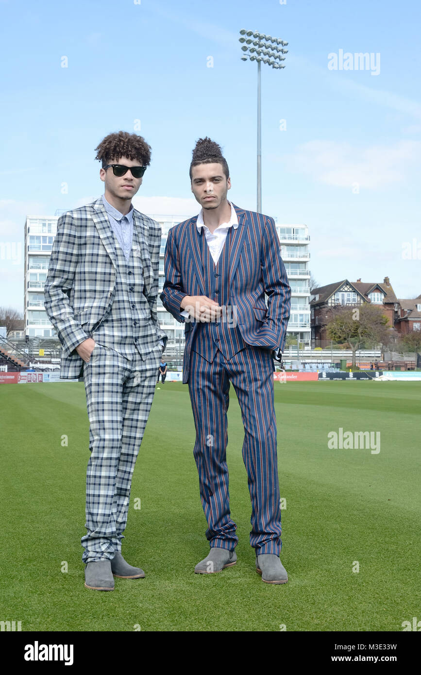 Zwei schöne und gemischten Rennen Kerle tragen maßgeschneiderte Anzüge sind in einem Cricket Ground - die Sonne scheint Stockfoto