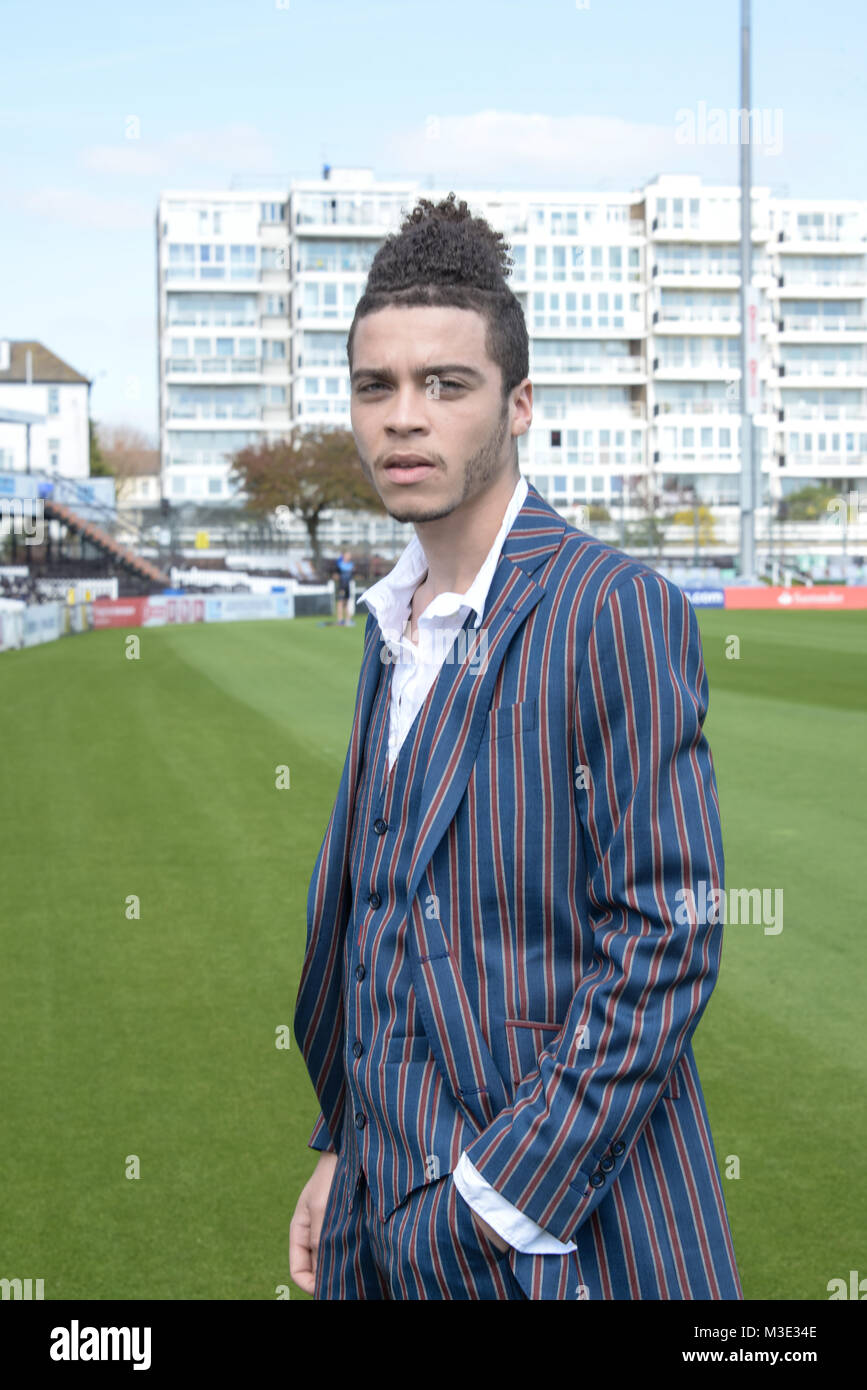 Ein schöner gemischter Rasse Kerl trägt einen gemusterten Anzug ist an einem Cricket Ground - die Sonne scheint Stockfoto