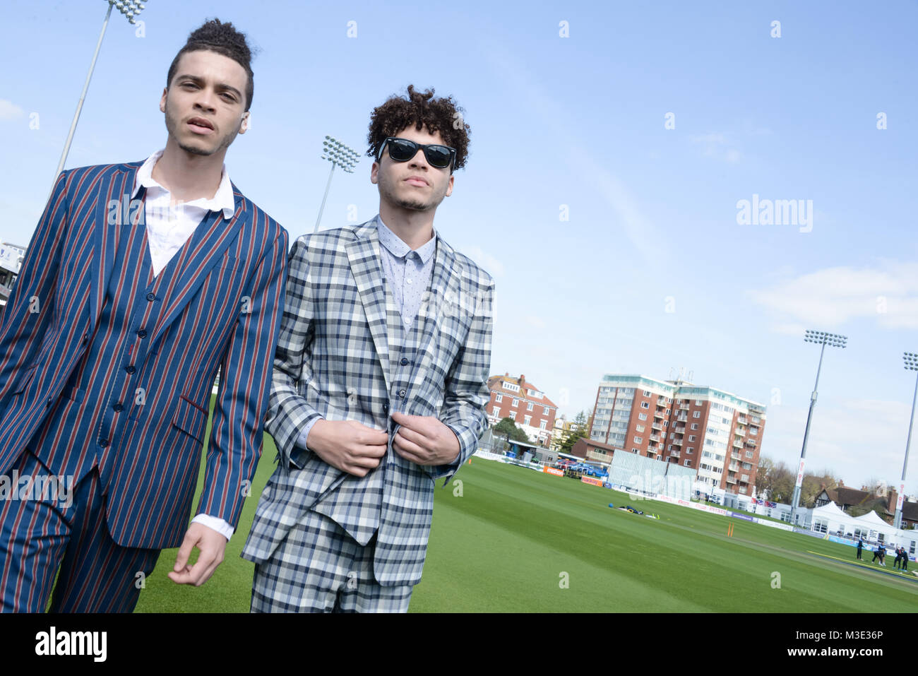 Zwei schöne und gemischten Rennen Kerle tragen maßgeschneiderte Anzüge sind in einem Cricket Ground - die Sonne scheint Stockfoto