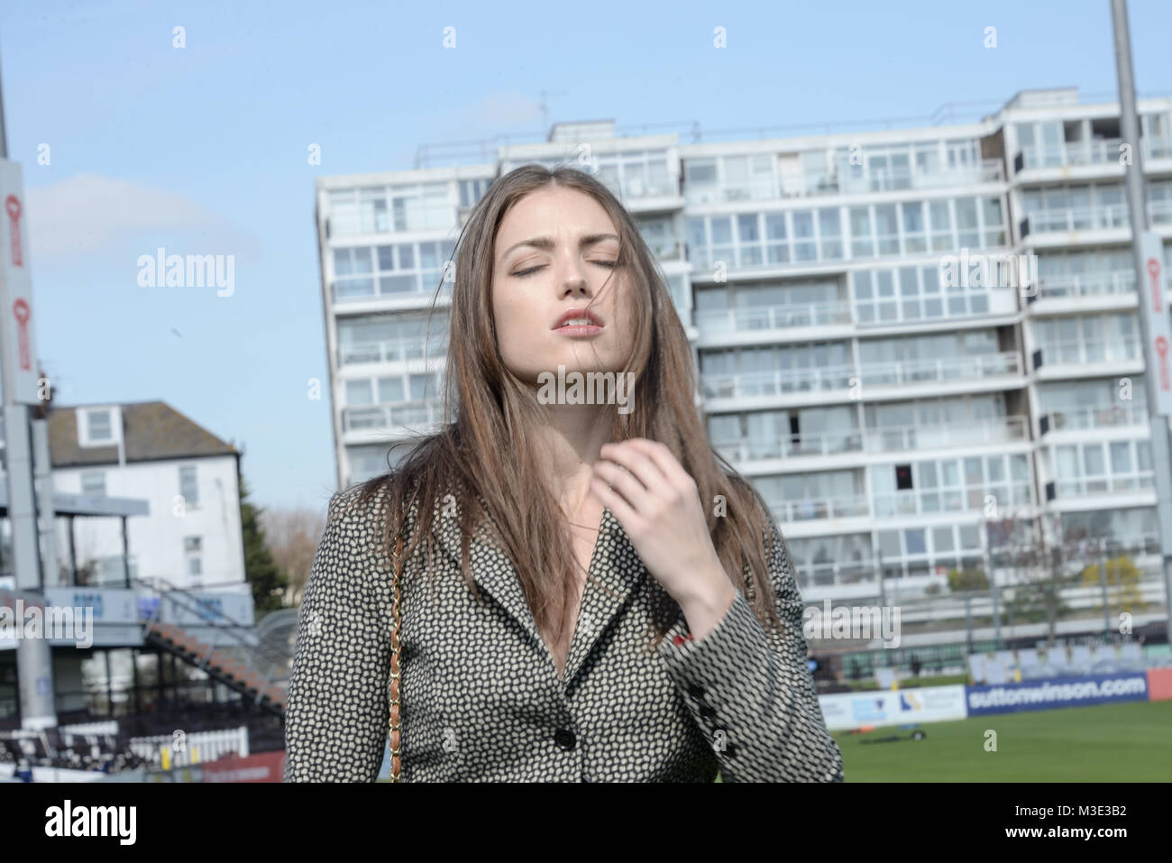 Ein schönes Mädchen mit einem maßgeschneiderten stilvolle gemusterten Anzug ist in einem Cricket Ground an einem schönen hellen Tag - sie ist zuversichtlich und durchsetzungsfähige Stockfoto