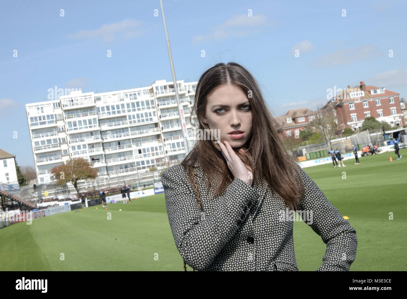 Ein schönes Mädchen mit einem maßgeschneiderten stilvolle gemusterten Anzug ist in einem Cricket Ground an einem schönen hellen Tag - sie ist zuversichtlich und durchsetzungsfähige Stockfoto