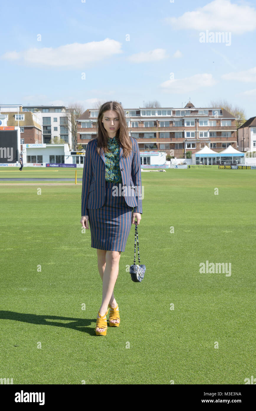 Ein schönes Mädchen mit einem maßgeschneiderten stilvolle gemusterten Anzug ist in einem Cricket Ground an einem schönen hellen Tag - sie ist zuversichtlich und durchsetzungsfähige Stockfoto