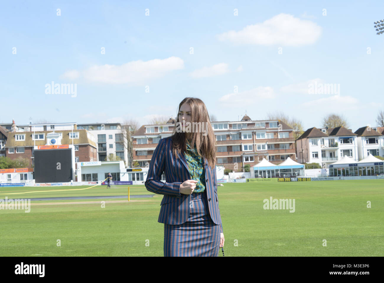 Ein schönes Mädchen mit einem maßgeschneiderten stilvolle gemusterten Anzug ist in einem Cricket Ground an einem schönen hellen Tag - sie ist zuversichtlich und durchsetzungsfähige Stockfoto