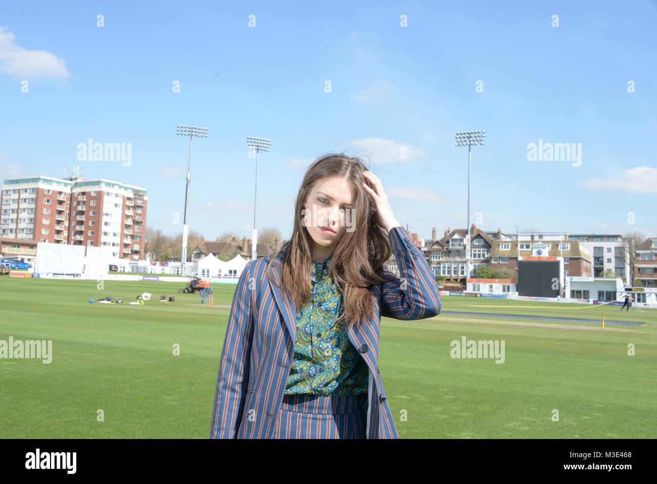 Ein schönes Mädchen mit einem maßgeschneiderten stilvolle gemusterten Anzug ist in einem Cricket Ground an einem schönen hellen Tag - sie ist zuversichtlich und durchsetzungsfähige Stockfoto