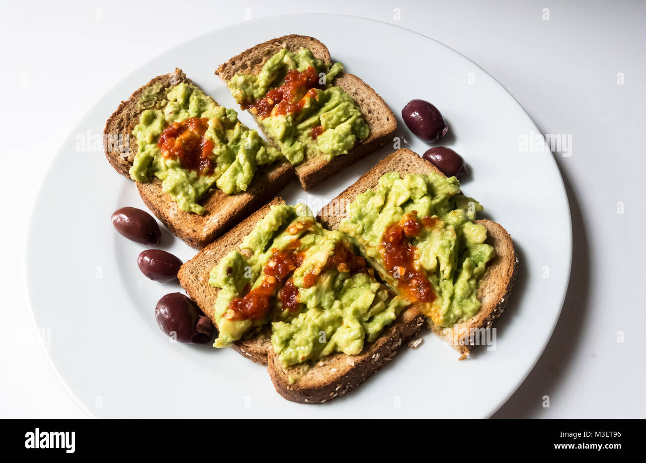 Avocado Toast mit Oliven und würzigen roten Sauce Stockfoto