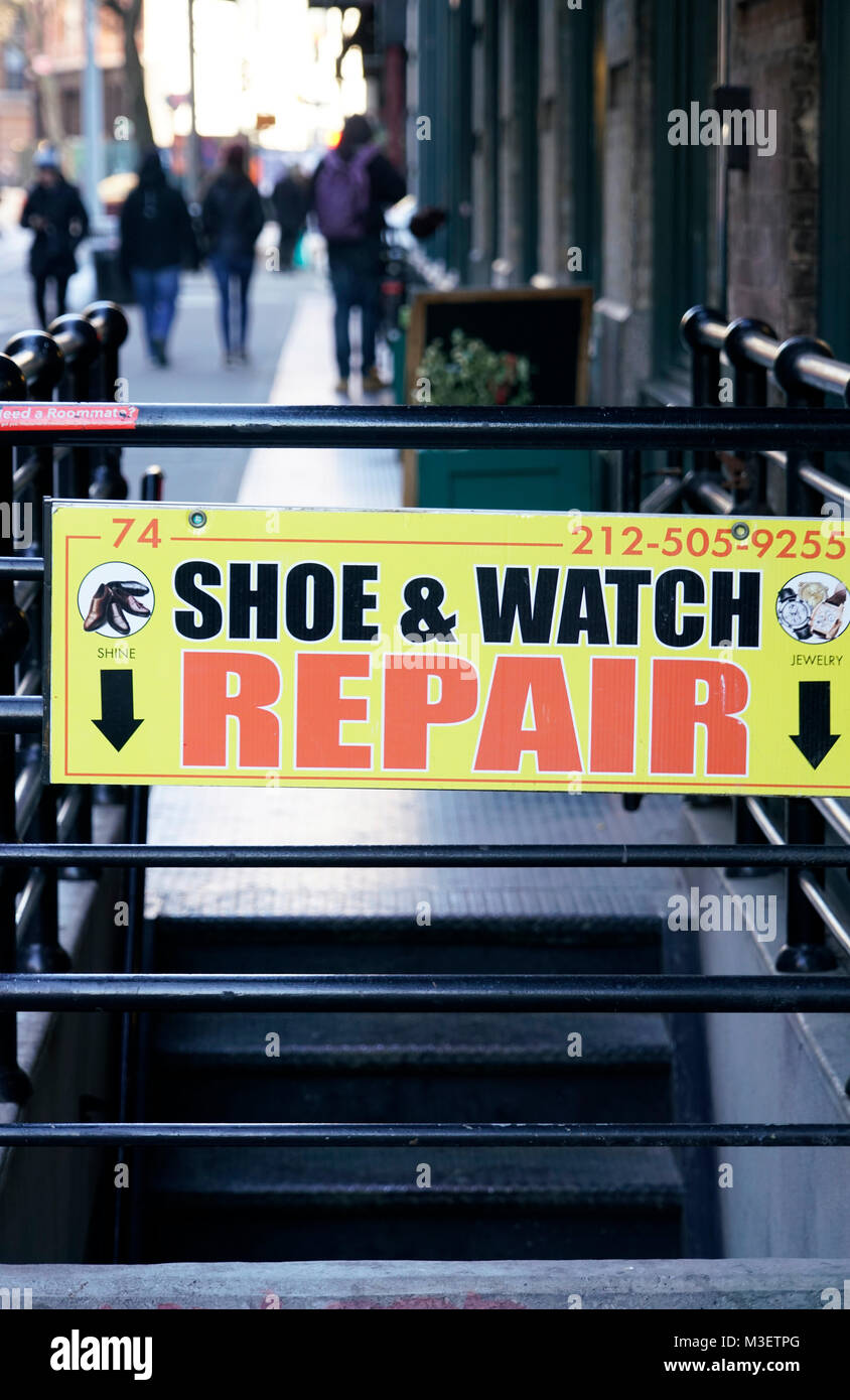 Schuh- und Watch repair Zeichen auf einem Untergeschoss Eingang auf Bürgersteig in Soho New York City USA. Stockfoto