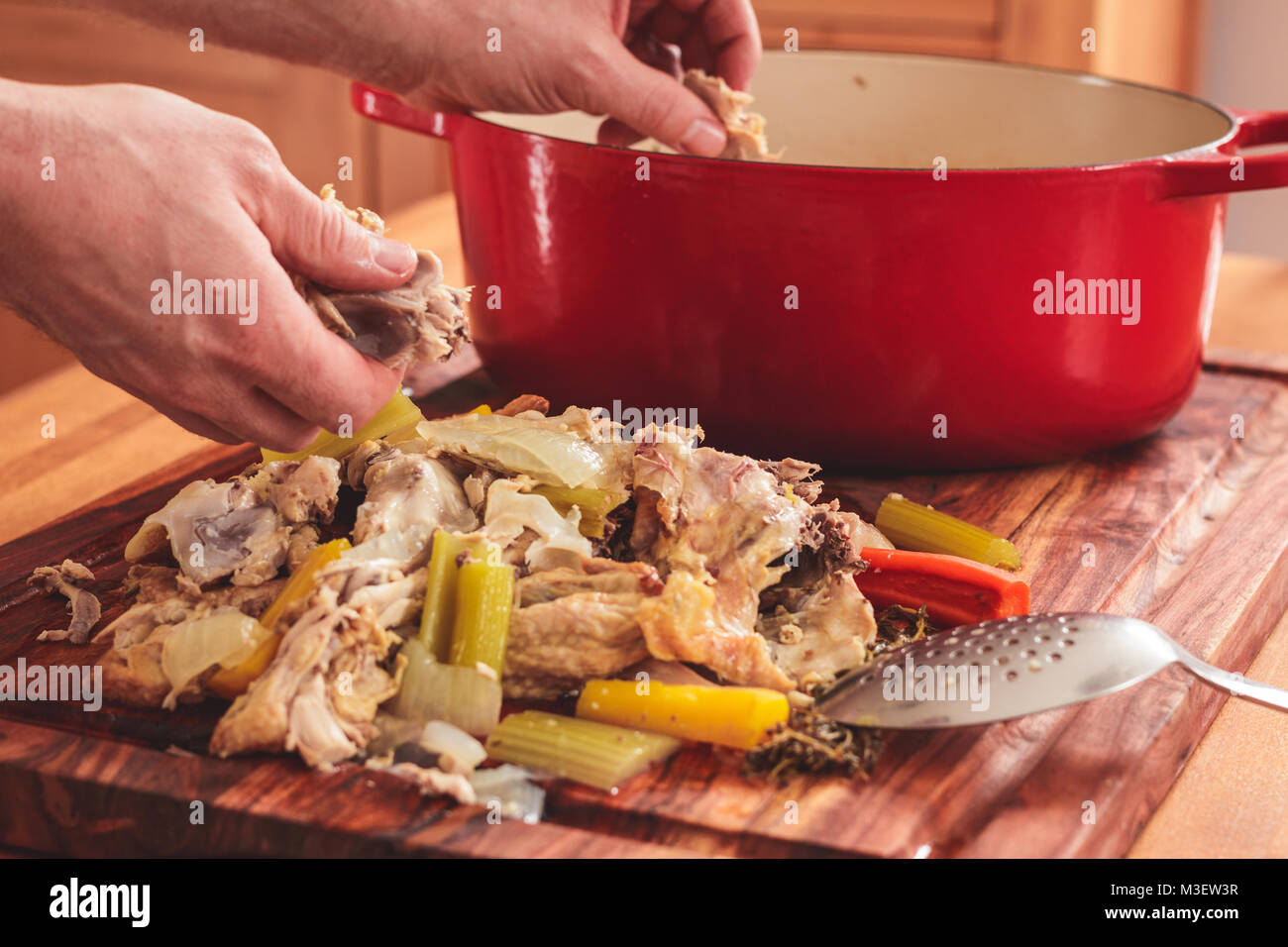 Trennen Sie das Fleisch von den Knochen nach dem Kochen übrig gebliebenen gebratenen Hähnchen. Das Fleisch wird dann wieder in den Suppentopf. Stockfoto