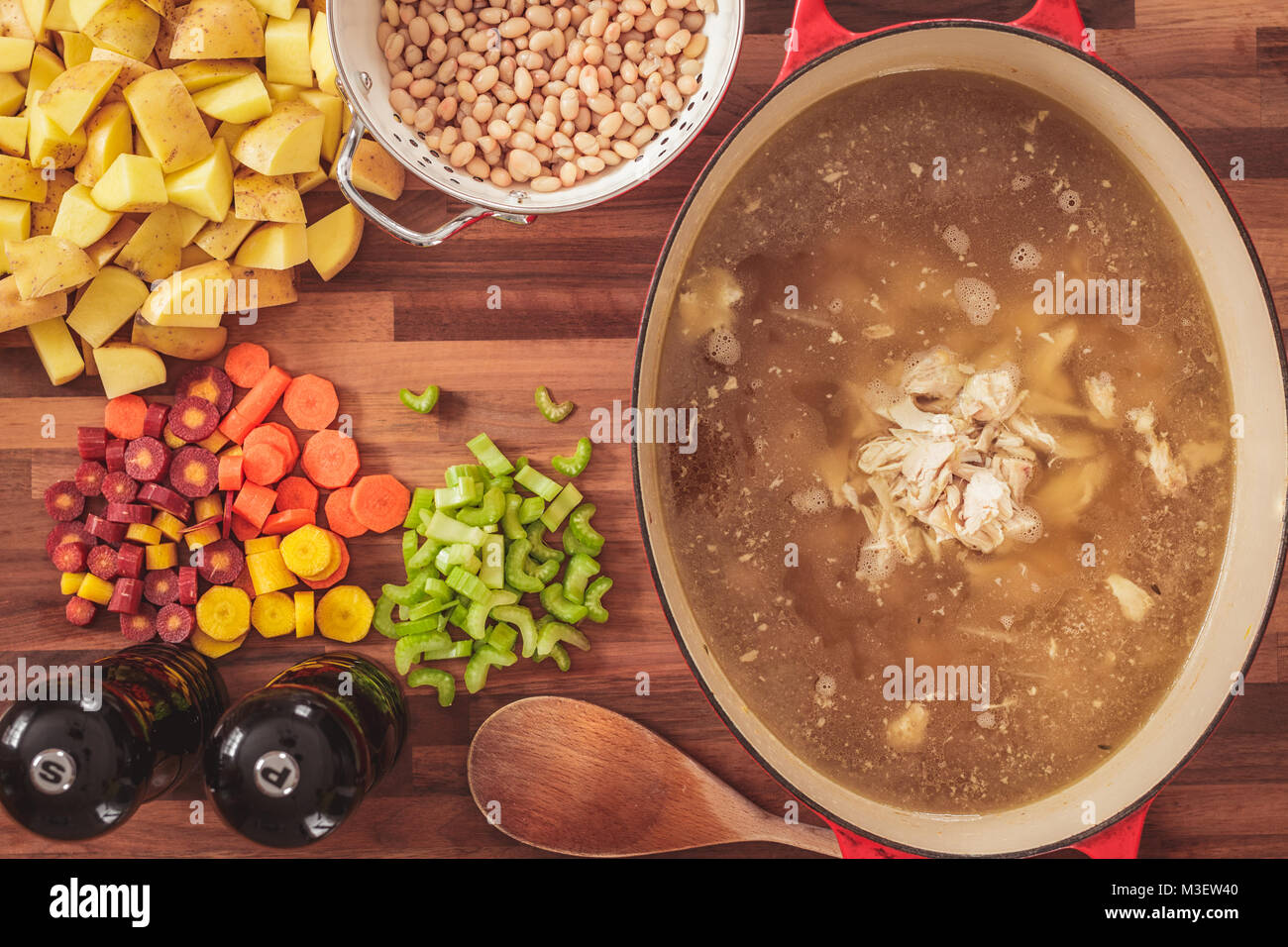 Ansicht des verwendeten Zutaten hausgemachte Huhn und weißen Bohnen Suppe zu machen. Zutaten gehören geschnittene Karotten, Sellerie, Kartoffeln, und weiß b Stockfoto