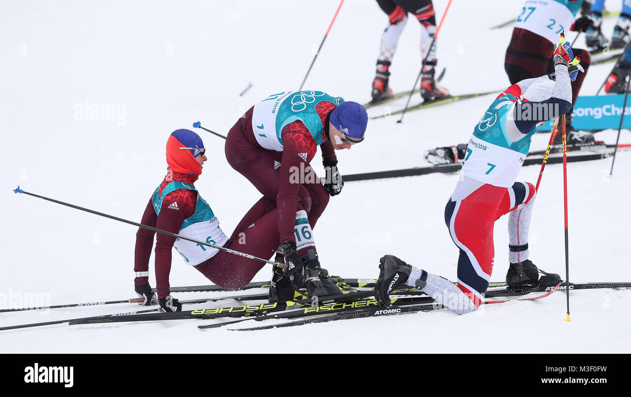 Etwaige Sieger Simen Hegstad Krueger Norwegen stürzt mit Andrey Larkov und Denis Spitsov der Ruder bei Beginn der Mens 15 km + 15 km Skiathlon am Alpensia Langlauf Center bei Tag zwei der Olympischen Winterspiele 2018 PyeongChang in Südkorea. Stockfoto