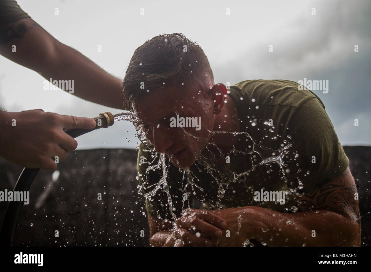 Us Marine Corps Cpl. Alex Deroster, Sitz Bataillon, Marine Corps Base Hawaii (MCBH), Flush Oleoresin capsicum (OC) Spray von seinen Augen nach Abschluss einer defensiven und offensiven Taktik Kurs an der Provost Marshal Office (PMO), MCBH, Feb 1, 2018. Der Kurs zielt darauf ab, Studenten PMO als Mitglieder des Gate augmentation Kraft zu unterstützen, indem sie die Wirkung von OC-spray aus erster Hand erleben ausstatten, um verantwortungsvoll die nicht-tödliche Waffe tragen. (U.S. Marine Corps Stockfoto