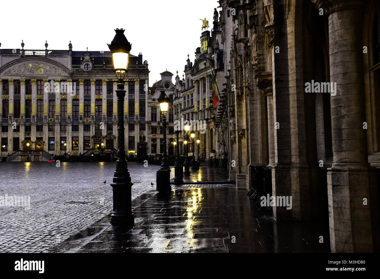 Brüssel Grand Place nach einem Regen wie die Lampe Beiträge eingeschaltet. Stockfoto