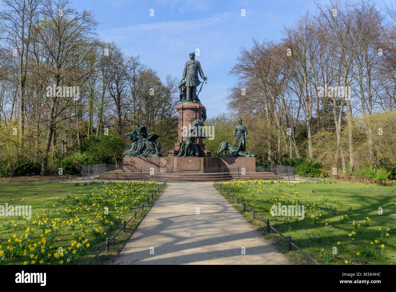 Farbe outdoor Foto der nationalen Denkmal Otto von Bismarck in Berlin, Deutschland, an einem hellen, sonnigen Frühlingstag, blauer Himmel, grünes Gras, gelbe Narzissen Stockfoto