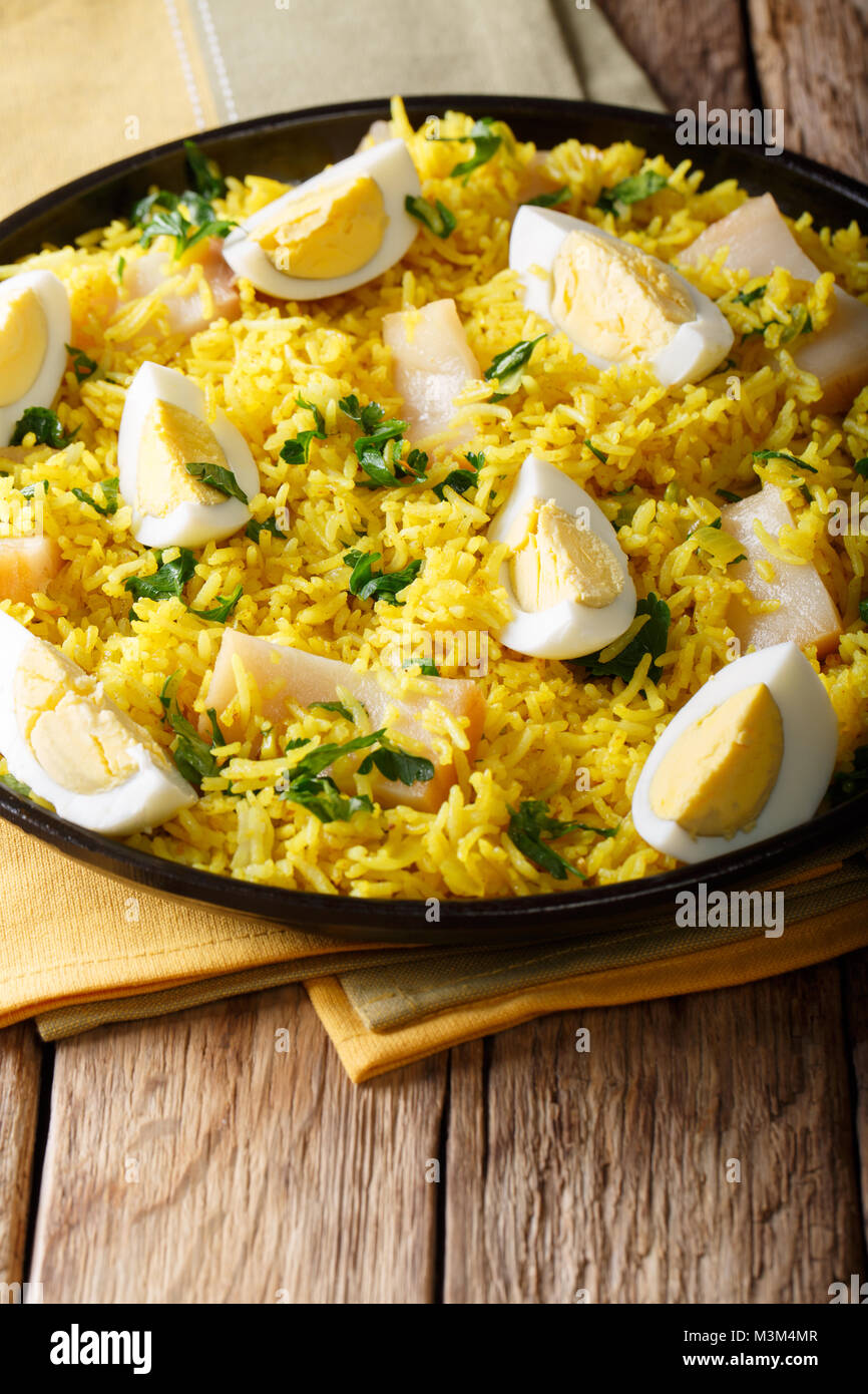 Traditionelles Essen: Kedgeree Reis mit geräuchertem Fisch, Eier, Gemüse und Gewürze close-up auf einem Teller. Vertikale Stockfoto