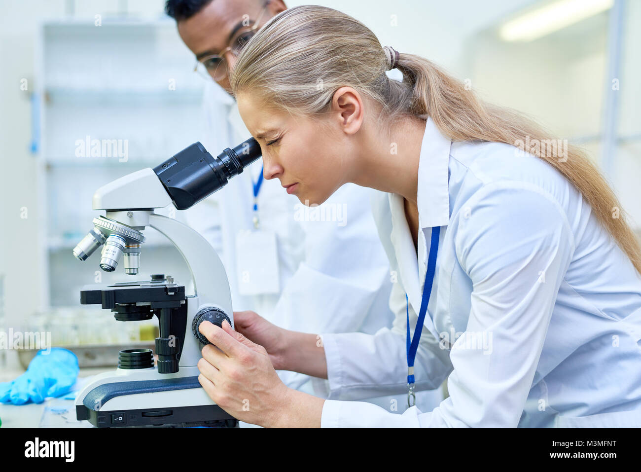 Wissenschaftlerin mit Mikroskop Stockfoto