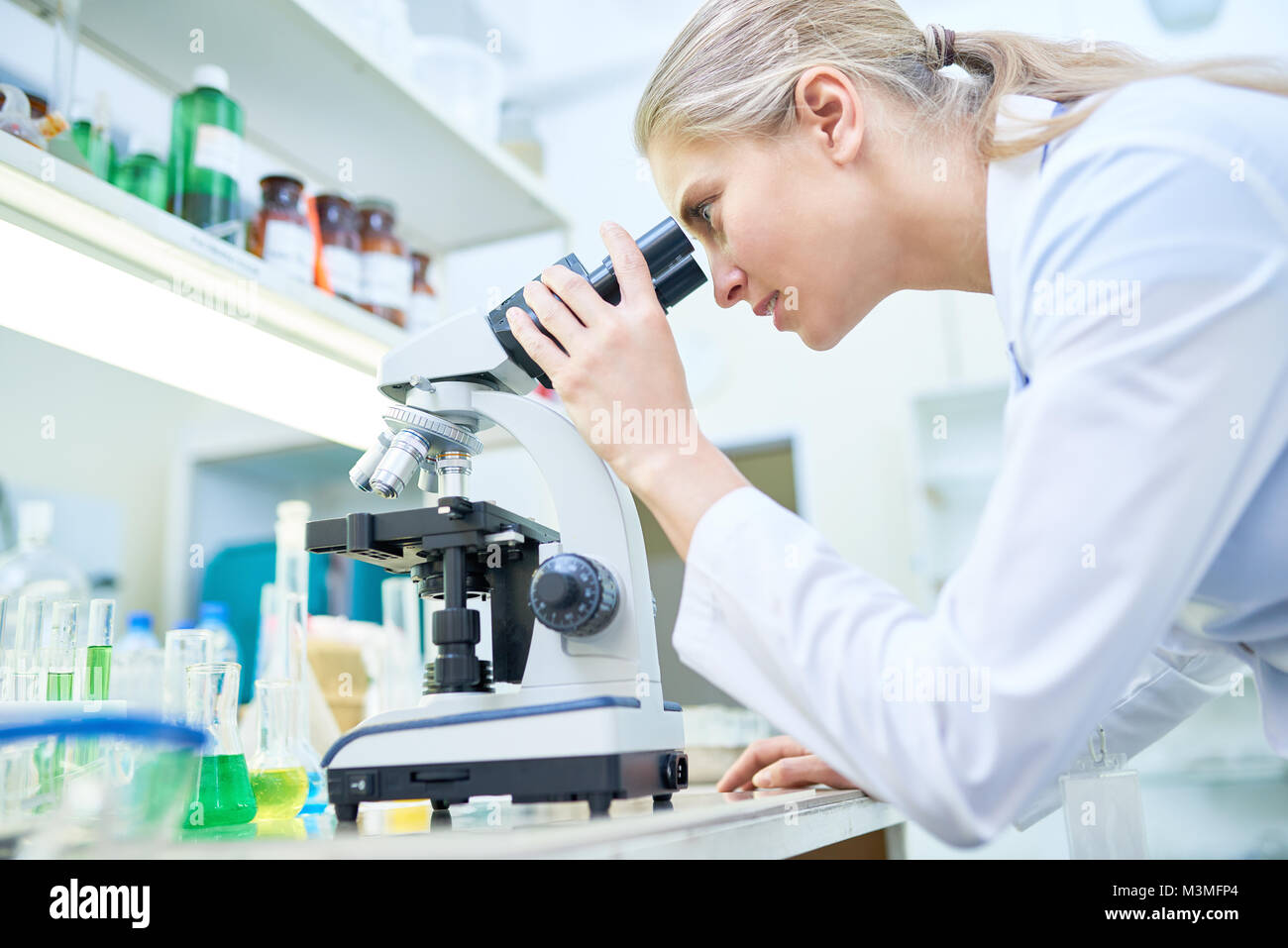 Wissenschaftlerin mit Mikroskop Stockfoto