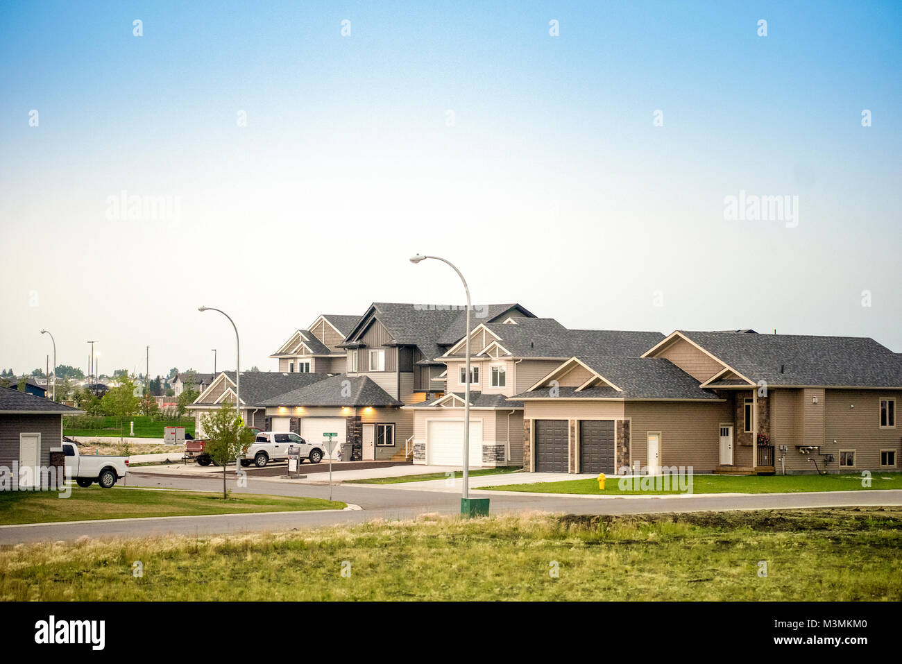 Große kanadische Häuser mit Fahrstraßen und Autos und blauer Himmel über Stockfoto