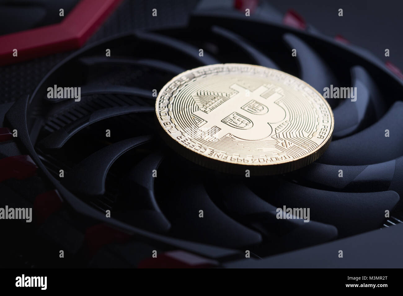 Cryptocurrency mining Konzept Nahaufnahme mit einem goldenen Bitcoin auf einem Computer Laser-show Grafikkarte schwarz Ventilator Stockfoto