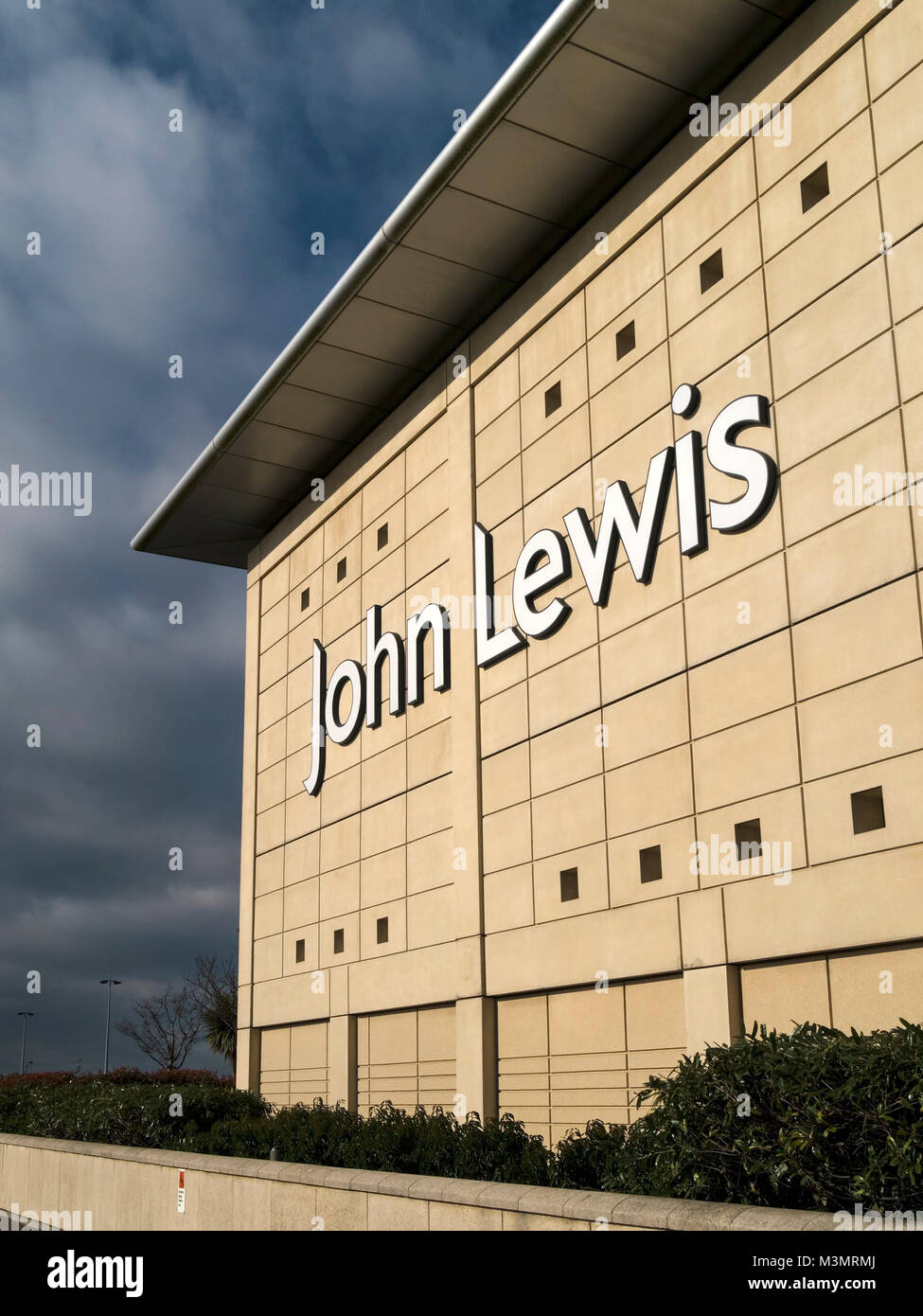 Große weiße John Lewis shop Logo auf sonnigen Außenwand von der Mall Cribbs Causeway mit dunklen Wolken, die in der Entfernung, Bristol, England, Großbritannien Stockfoto