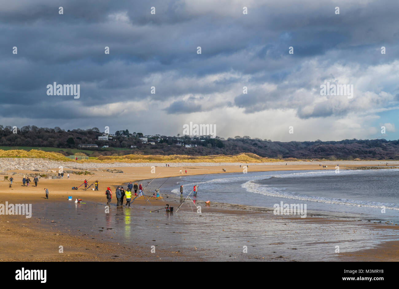 Menschen Flanieren auf der Newton Strand Porthcawl an einem windigen, sonnigen Wintertag, South Wales South Wales Coast, South Wales Küste, Stockfoto