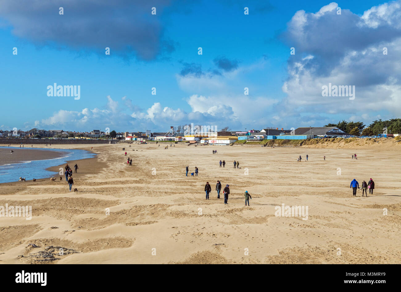 Sandy Bay, Porthcawl, mit Menschen für einen Spaziergang an einem sonnigen und windigen Wintertag, South Wales Stockfoto