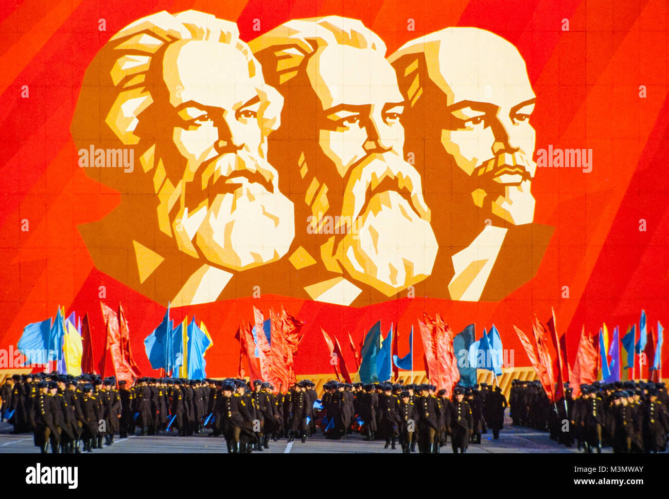 Russische Soldaten üben für eine Parade unter einem Gemälde von Lenin, Engels und Marx in St. Petersburg, Russland. Stockfoto